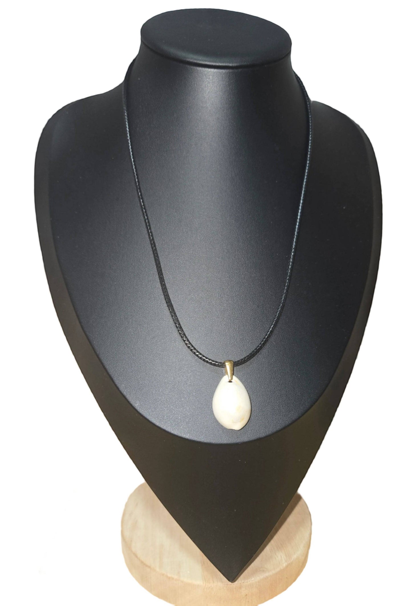 KRE PRIME handcrafted white shell pendant on a black cord necklace, inspired by African design.