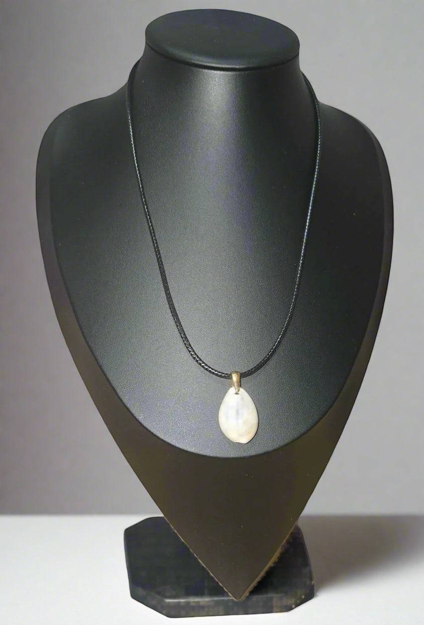 KRE PRIME handcrafted teardrop shell pendant necklace on a black cord, with a brass bail.