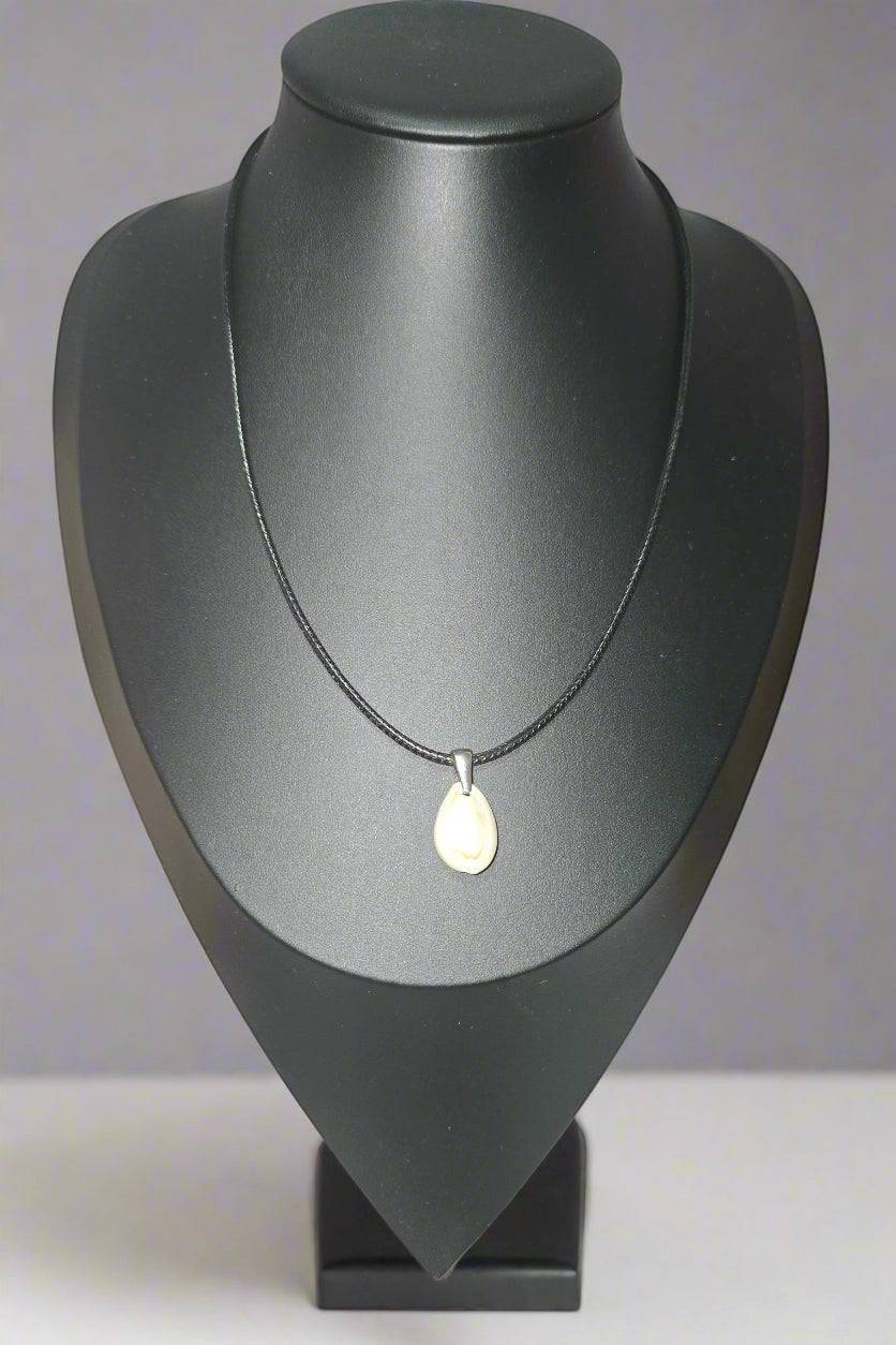 KRE PRIME handcrafted pendant necklace with a natural, off-white shell on a black cord. Features a teardrop shape and silver bail.