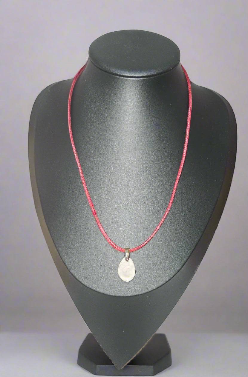 KRE PRIME handcrafted African shell pendant necklace with a silver bail on a thin red cord.