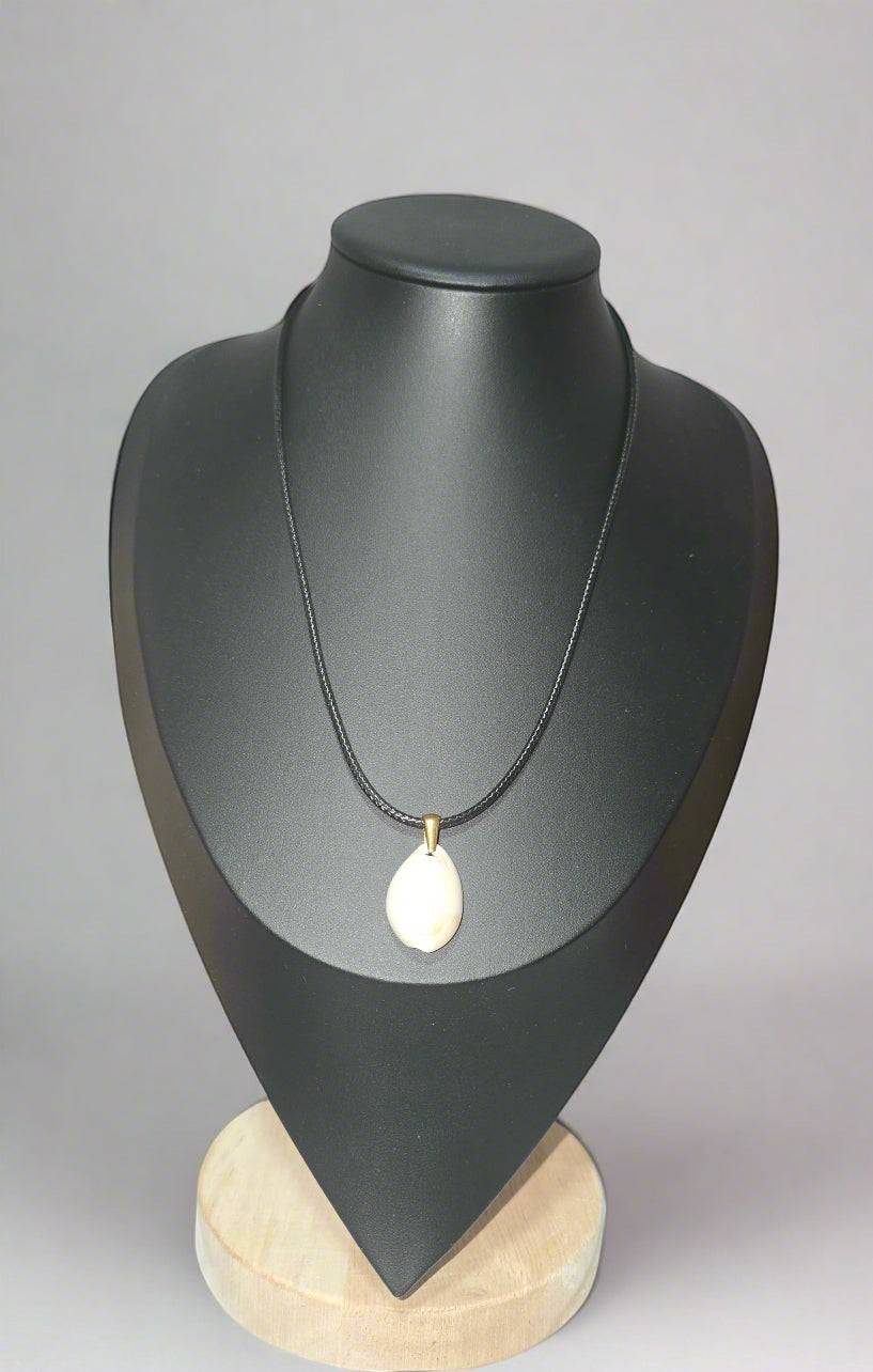 KRE PRIME handcrafted white shell pendant necklace on a black cord with brass accent.