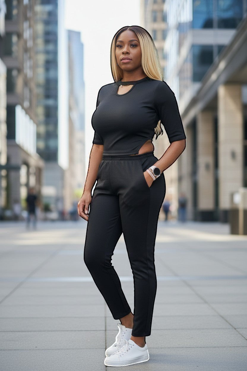 KRE Prime black convertible jumpsuit with cut-out detail and elastic waist pants, worn by a woman outdoors.