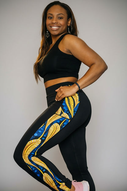 KRE Prime black leggings with a vibrant blue and yellow peacock feather print down the side, featuring pockets.