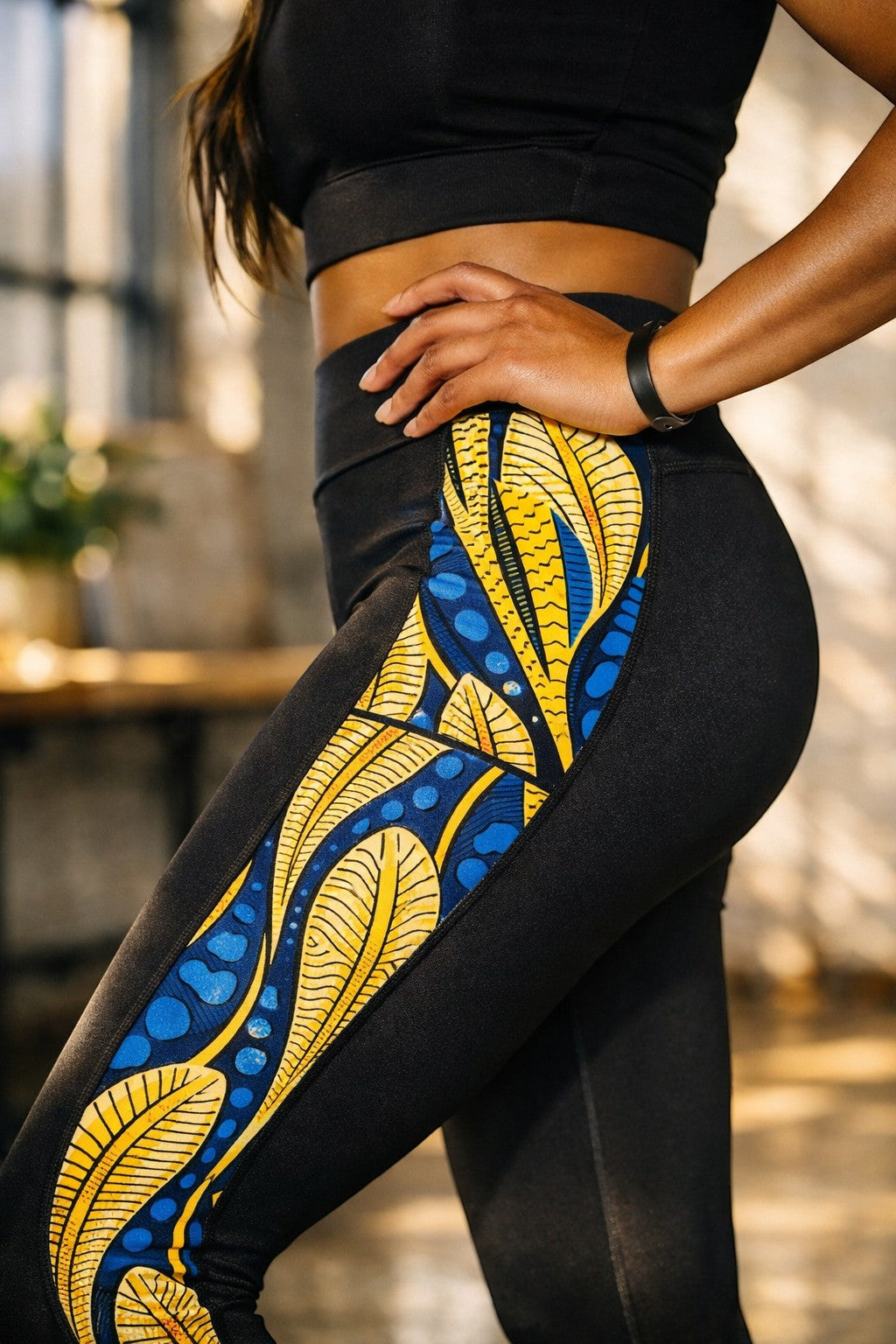 KRE Prime women's black leggings with vibrant yellow and blue peacock feather print side panels and pockets.