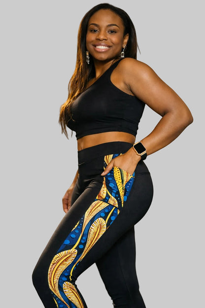 KRE Prime black leggings with side pockets featuring a vibrant blue and yellow feather-like print. Made of polyamide and spandex.