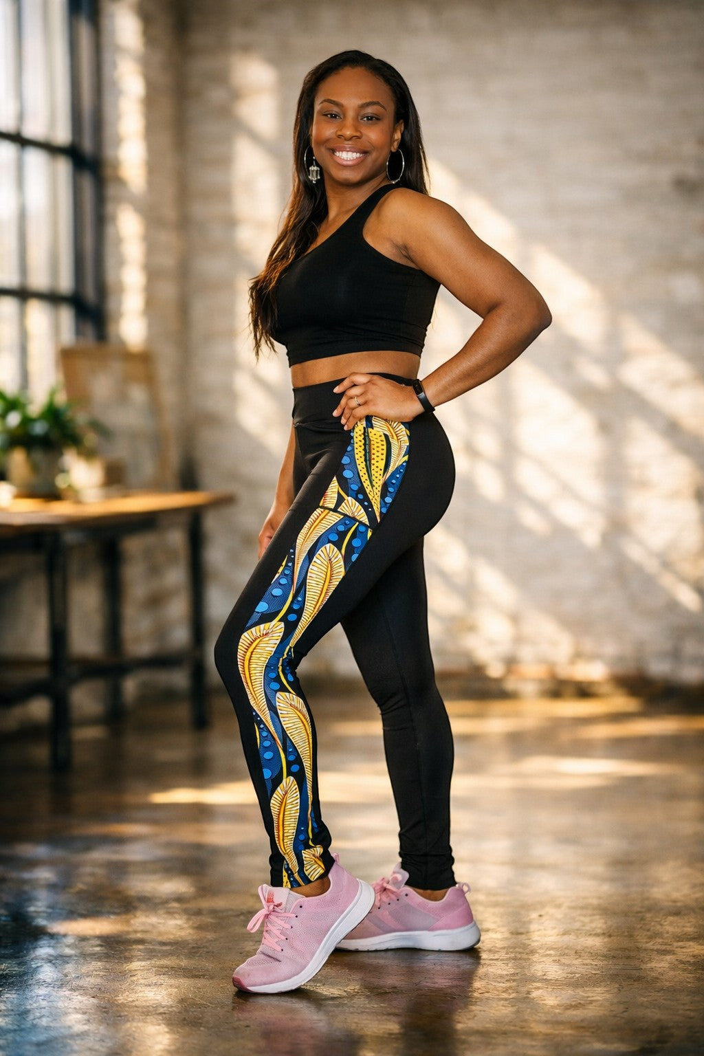 KRE Prime women's black leggings with a bold yellow and blue feather-like print down the side. Made of polyamide and spandex.