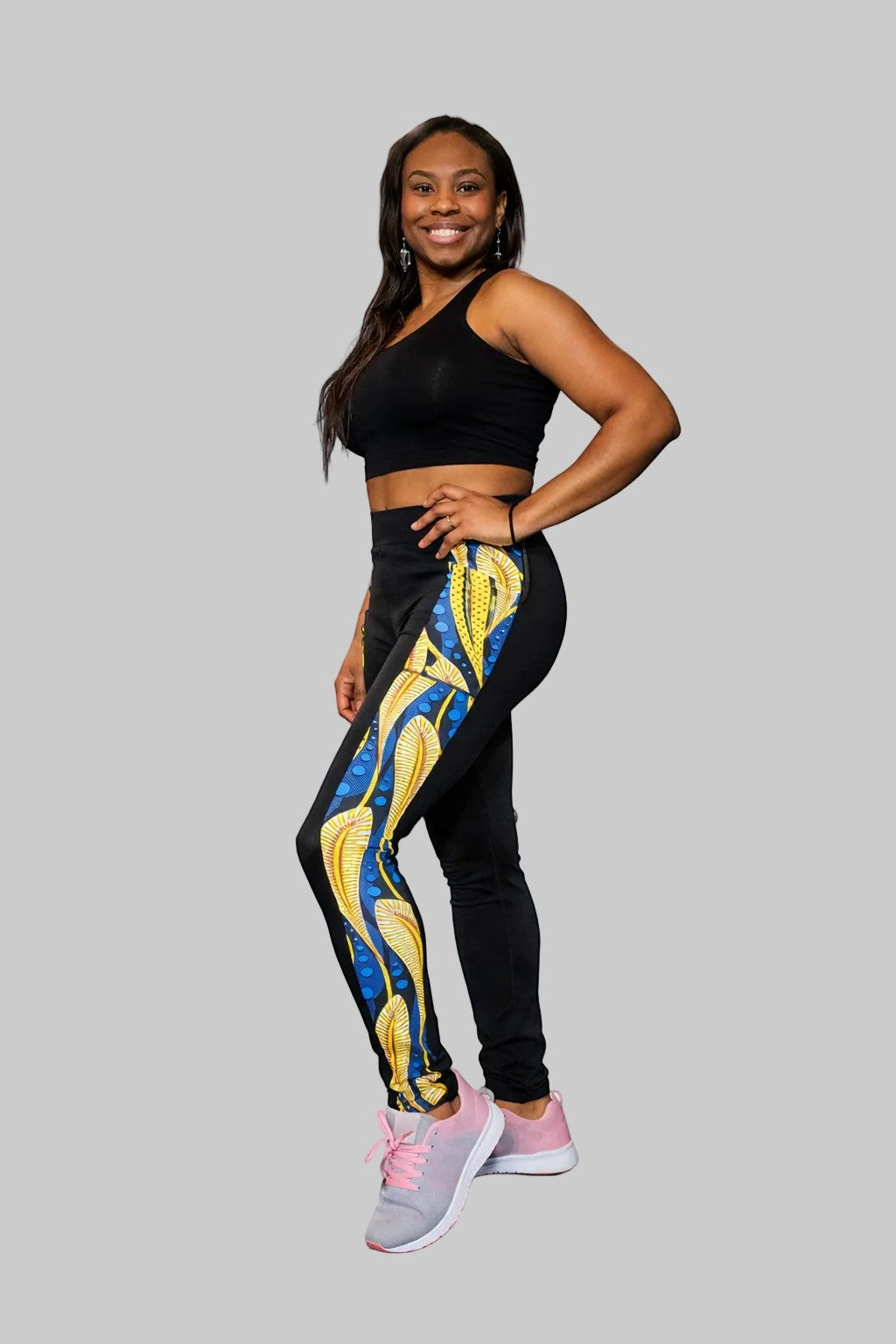 KRE Prime women's black polyamide and spandex leggings with a bold yellow and blue abstract print down the side and pockets.