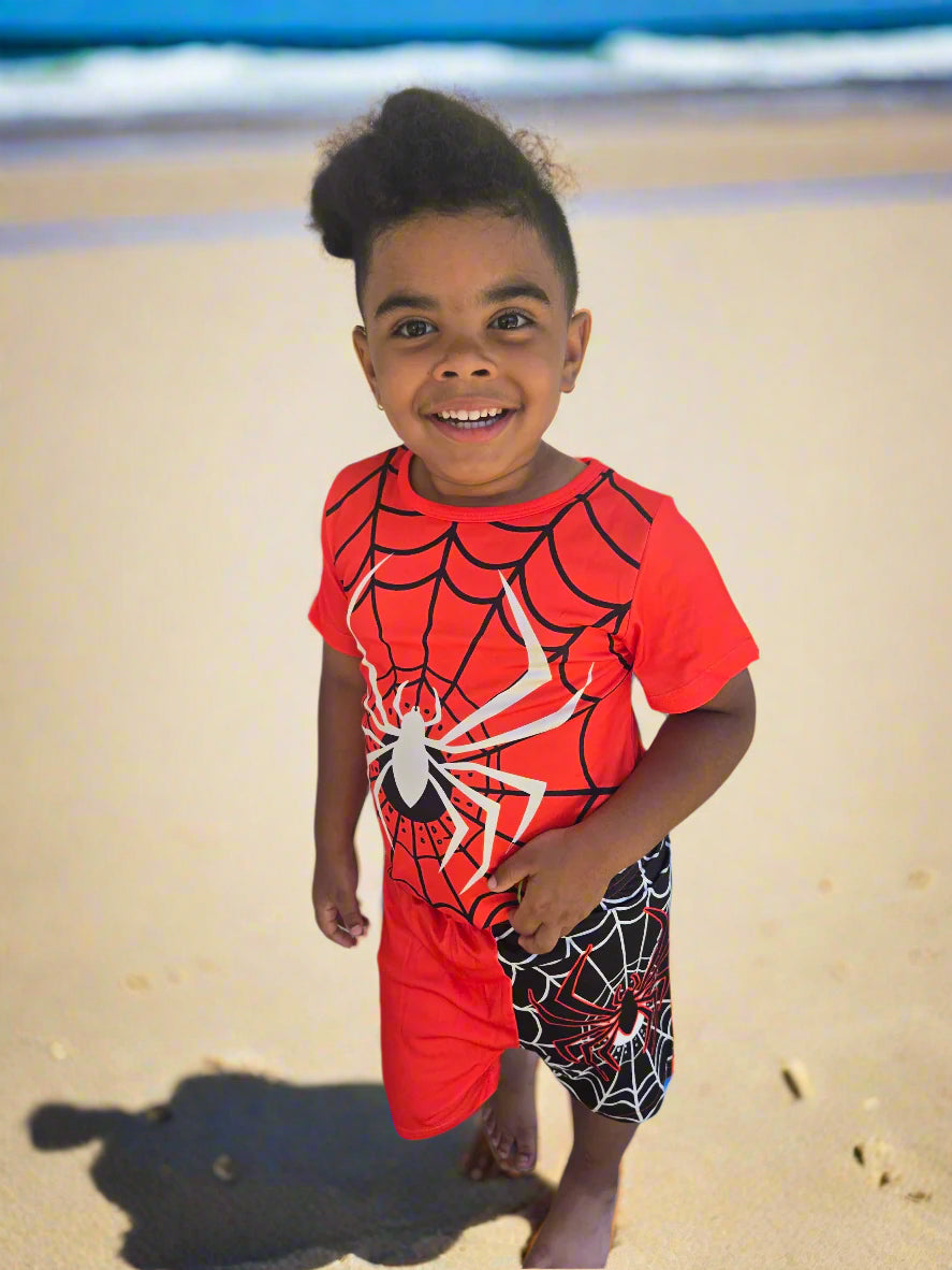 Child wearing a Spider-Man outfits on a beach